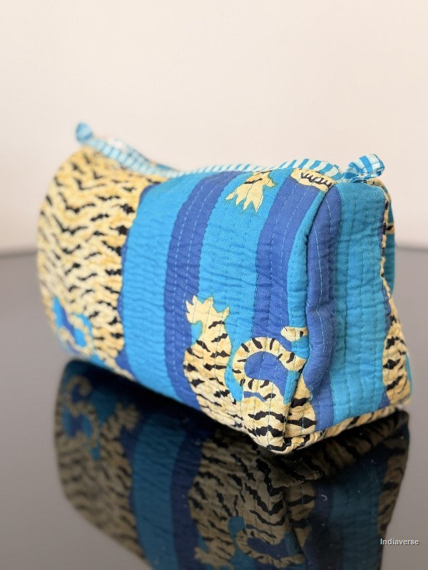 Blue and yellow striped pouch with tiger design on a reflective surface