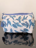 toiletry pouch with blue hummingbirds on a glass surface