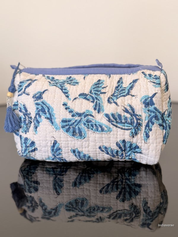 toiletry pouch with blue hummingbirds on a glass surface