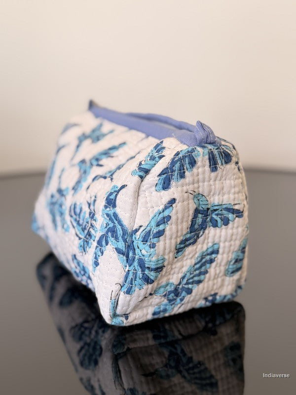Fabric pouch with blue floral pattern on a reflective surface
