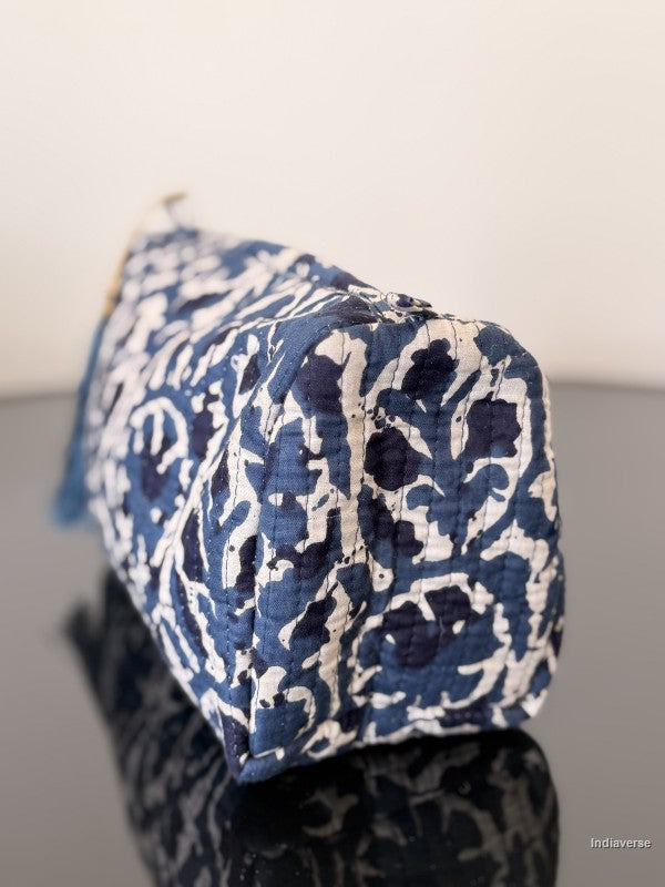 Blue and white patterned pouch on a reflective surface with a neutral background