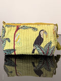 lime color toiletry pouch with jungle print sitting on a glass surface
