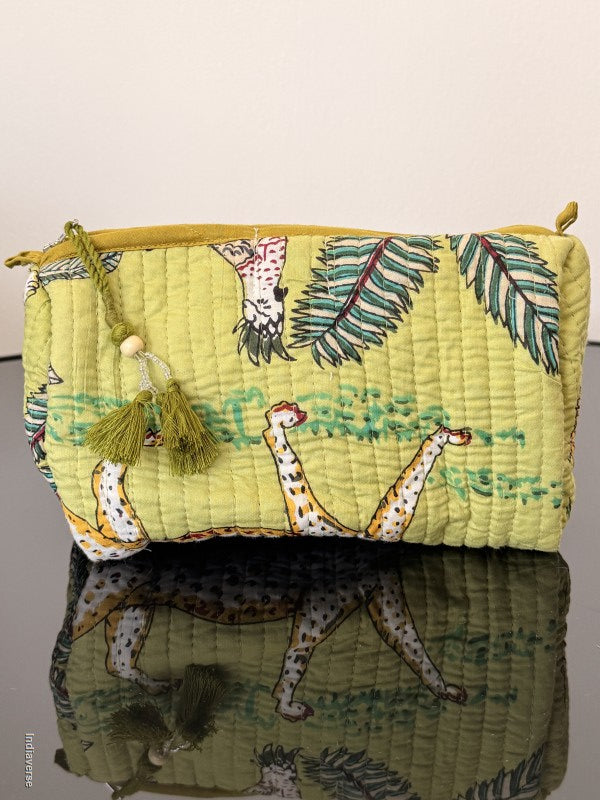 view from the other side of the bag with green tassel sitting on a smooth surface