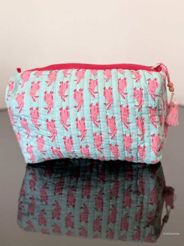 Fabric pouch with pink crab pattern on a reflective surface
