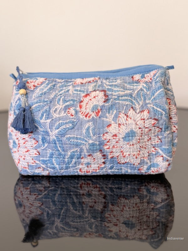 Floral patterned pouch with blue trim on a reflective surface