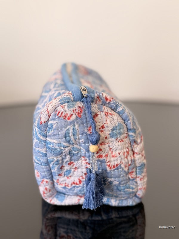 Floral-patterned fabric roll with tassels on a reflective surface