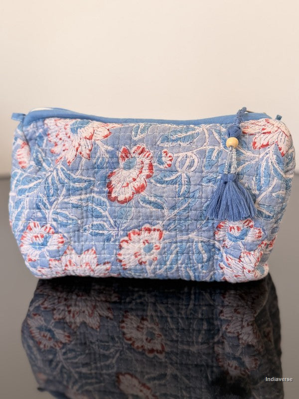 Floral patterned pouch with tassel on a reflective surface
