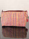 Two striped bags, one pink and yellow, the other brown and purple, on a beige background.