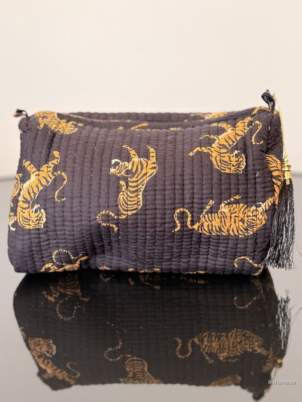 Black pouch with gold tiger patterns on a reflective surface