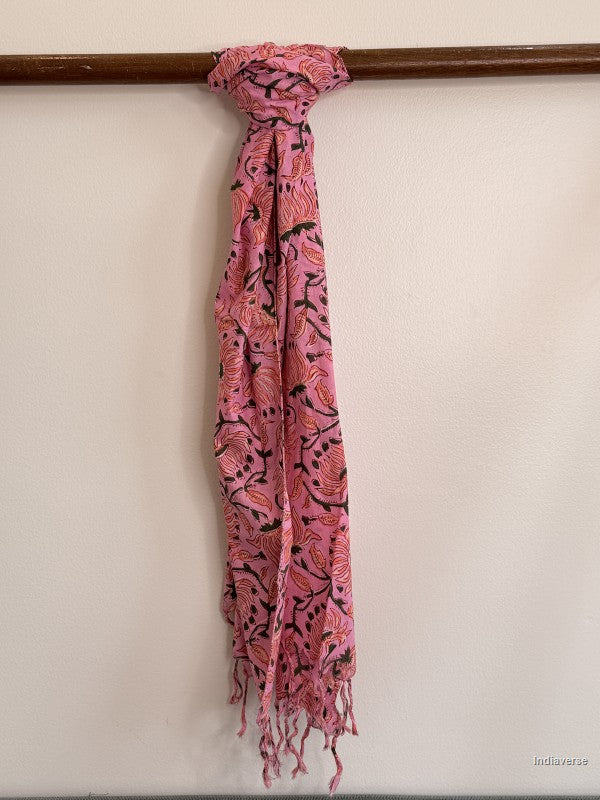 Pink cotton scarf with orange flower design tied to a wooden beam