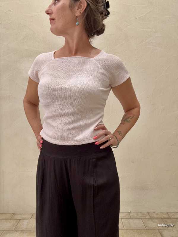 close up of black palazzo pants in front of beige wall