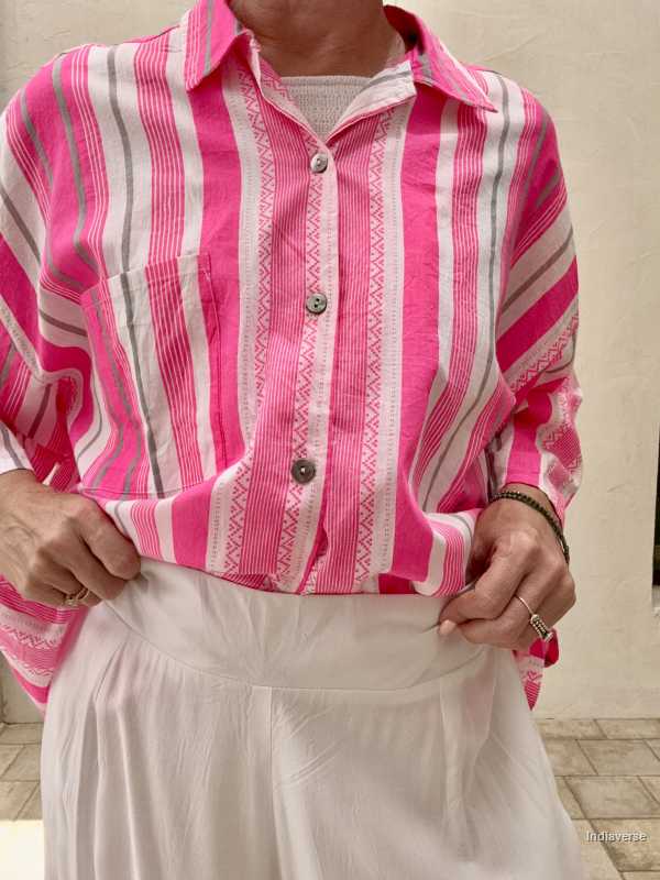 Person wearing a pink and white striped shirt with a neutral background