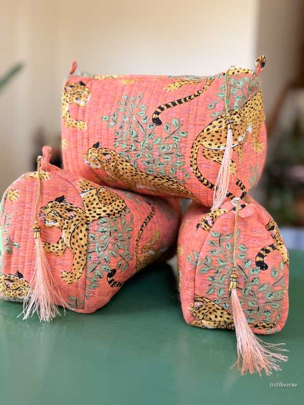 Pink pouches with leopard designs and tassels on a green surface | Peach Leopard