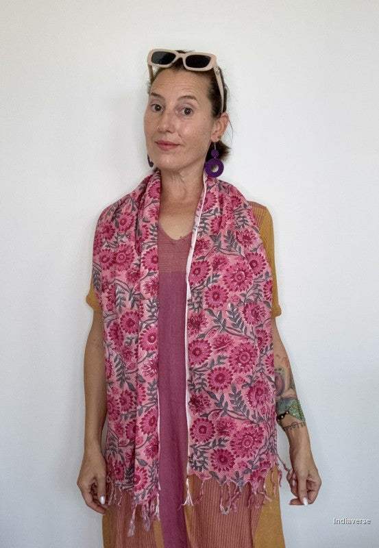 woman wearing a pink cotton scarf standing in front of a white wall