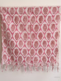 pink cotton scarf with geometric lotus design hanging from a wooden beam