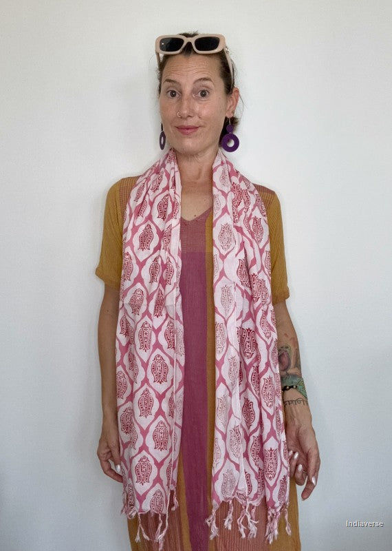 woman wearing a white cotton scarf with lotus design standing in front of a white wall