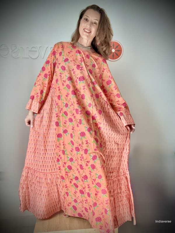 Woman wearing a pink floral dress against a plain background