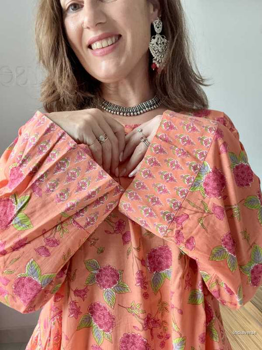 Woman wearing a floral off-shoulder dress with a plain background