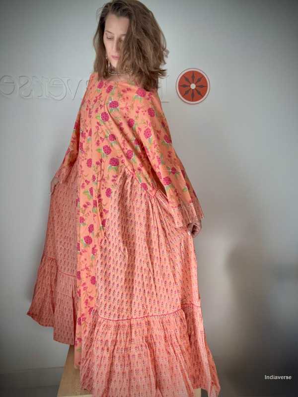 Woman wearing a pink floral dress against a plain background