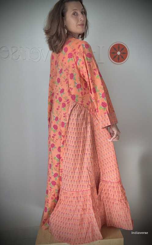 Woman wearing a long, floral-patterned dress against a plain background