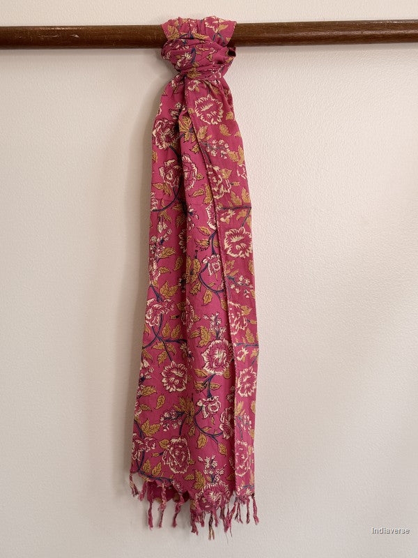 a pink cotton scarf with floral design tied to a wooden beam