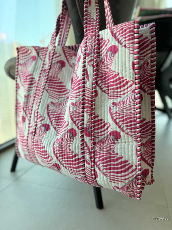 Quilted tote bag with pink floral pattern on a light background