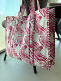 Quilted tote bag with pink floral pattern on a light background