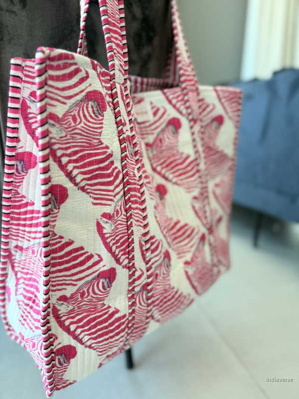 Tote bag with pink and white zebra pattern on a blurred indoor background