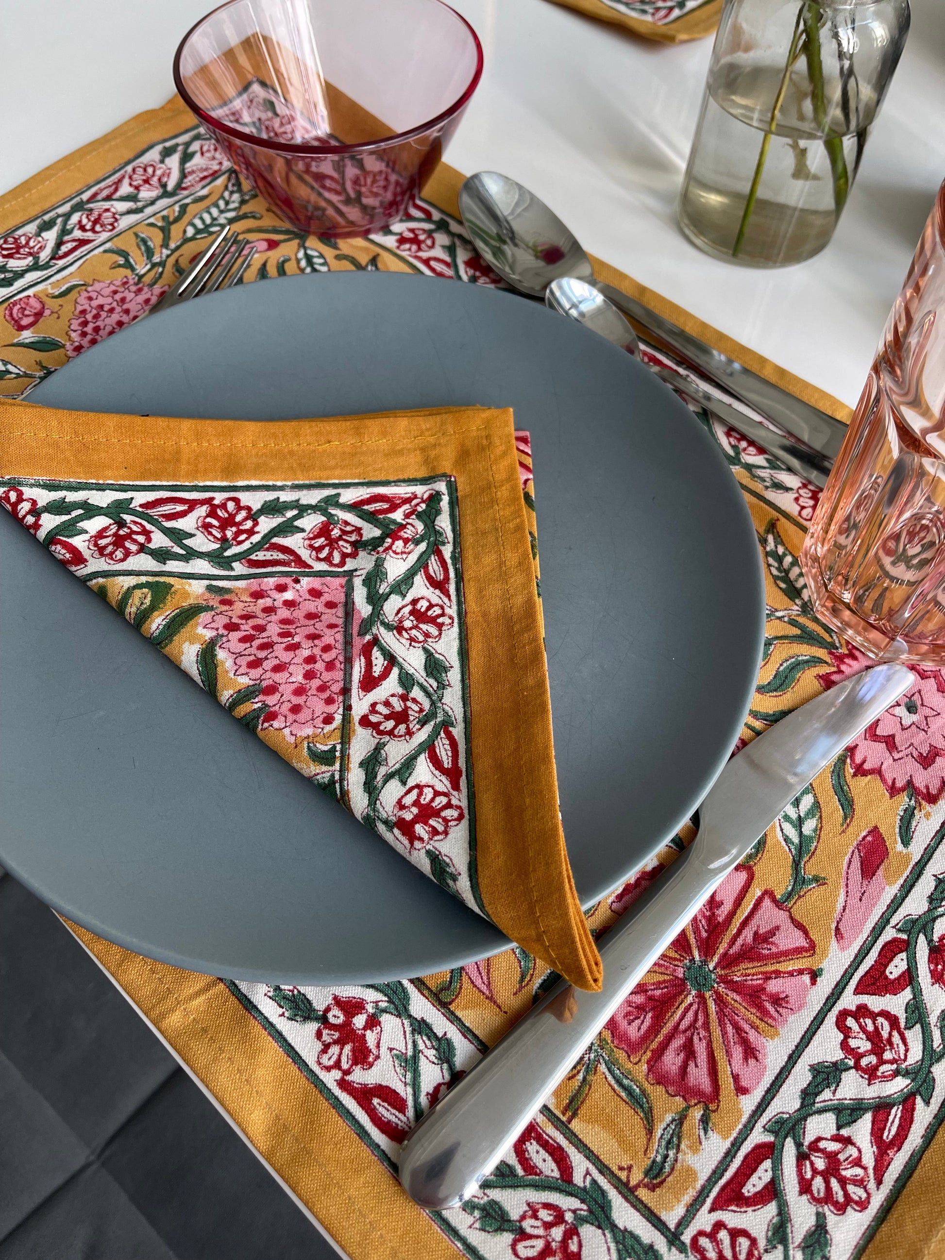 Gray plate with a patterned napkin on a decorative tablecloth.