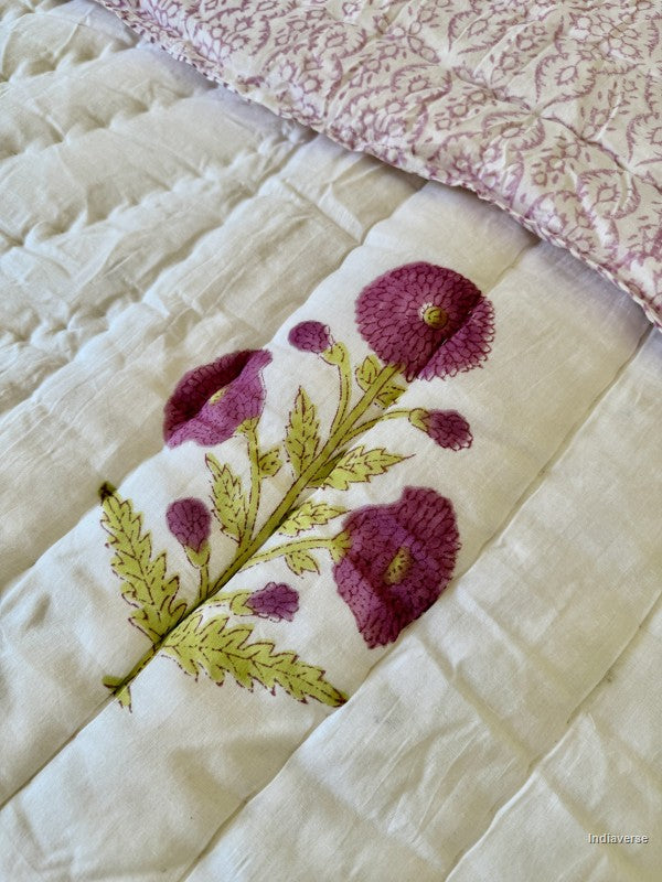 Close up of the purple flower print from the white quilted blanket