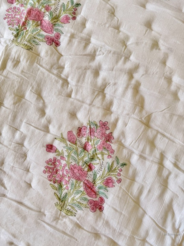 Pink and white floral print on a quilt close up