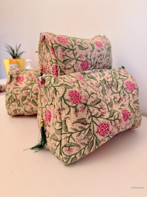 Three fabric cosmetic pouches with a pink and green floral block print on a beige background, arranged on a light surface against a plain wall | Rose Garden Beige