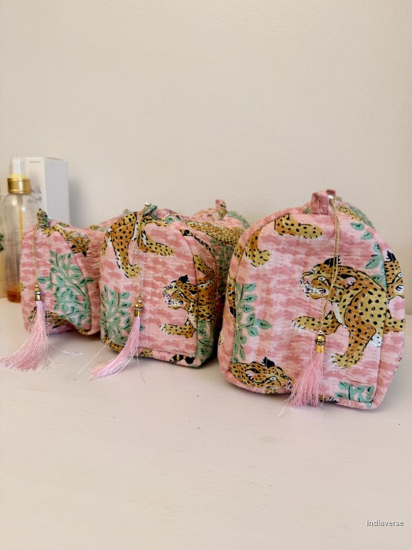 Three pink drawstring cosmetic pouches with a leopard print pattern and pink tassels, arranged on a light surface against a plain beige background | Rose Leopard