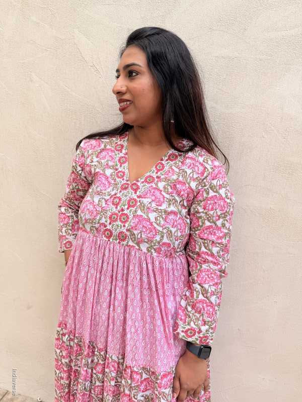 Woman wearing a pink floral dress lying on a beige carpet