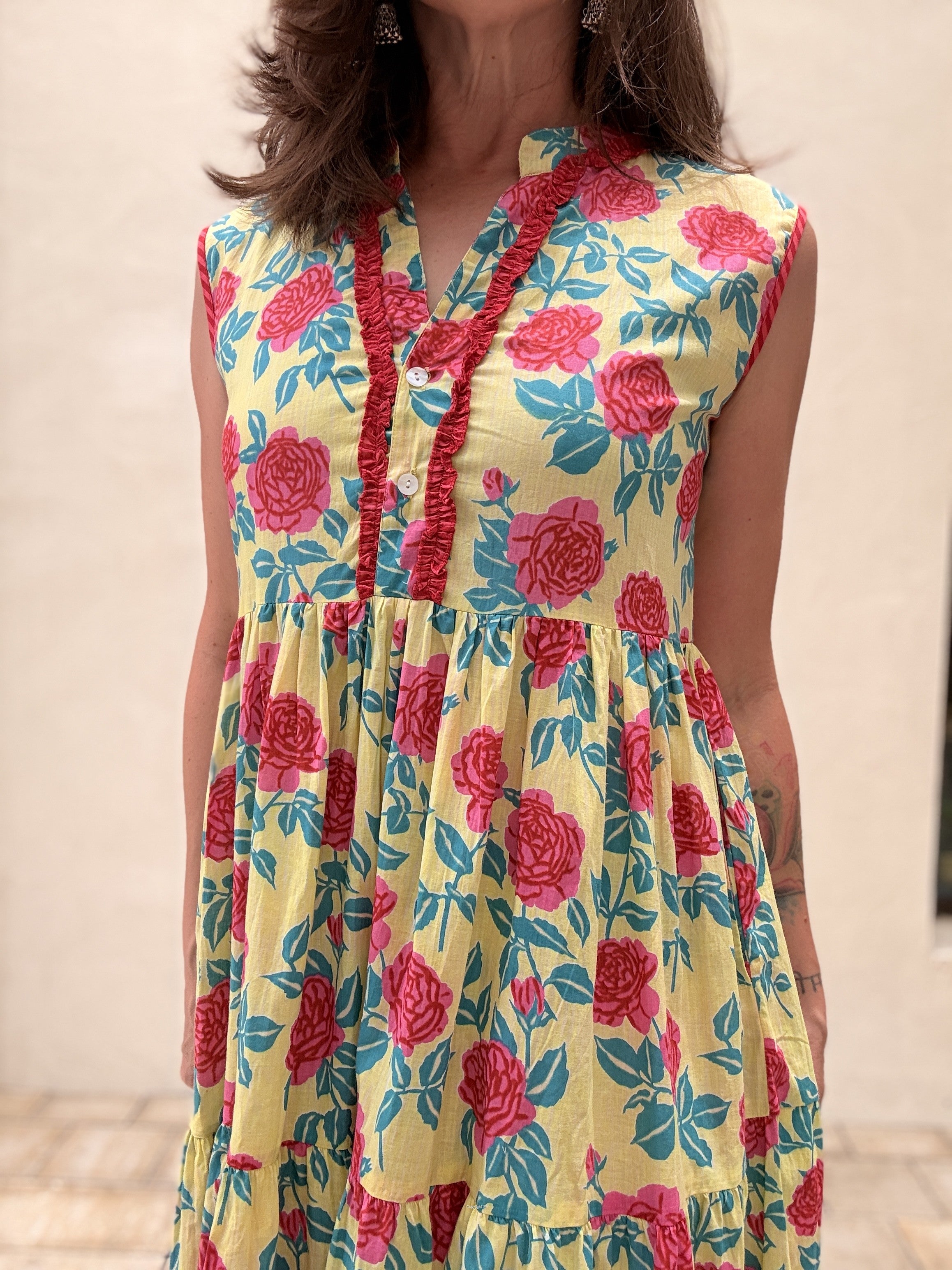 Woman wearing a colorful floral dress with a neutral background