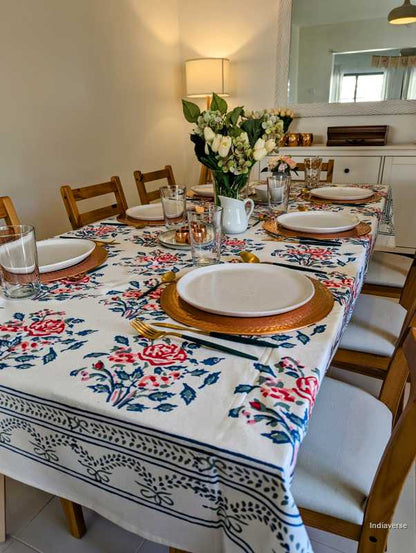 Dining table set with a floral rose tablecloth in a kitchen setting
