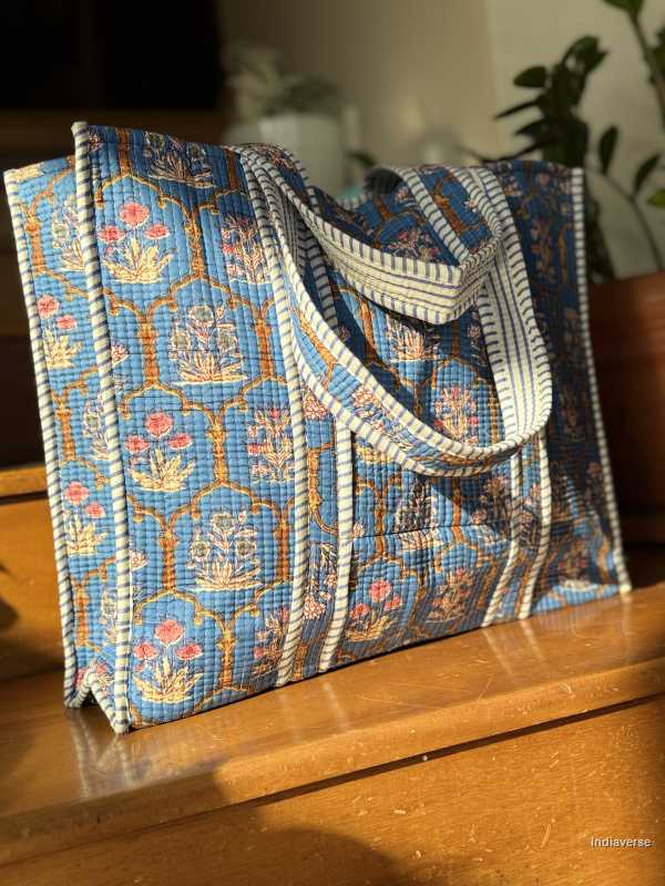 Blue patterned tote bag on a wooden surface with a blurred background