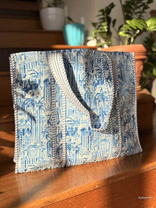 Blue patterned cotton tote bag on a wooden surface with blurred background