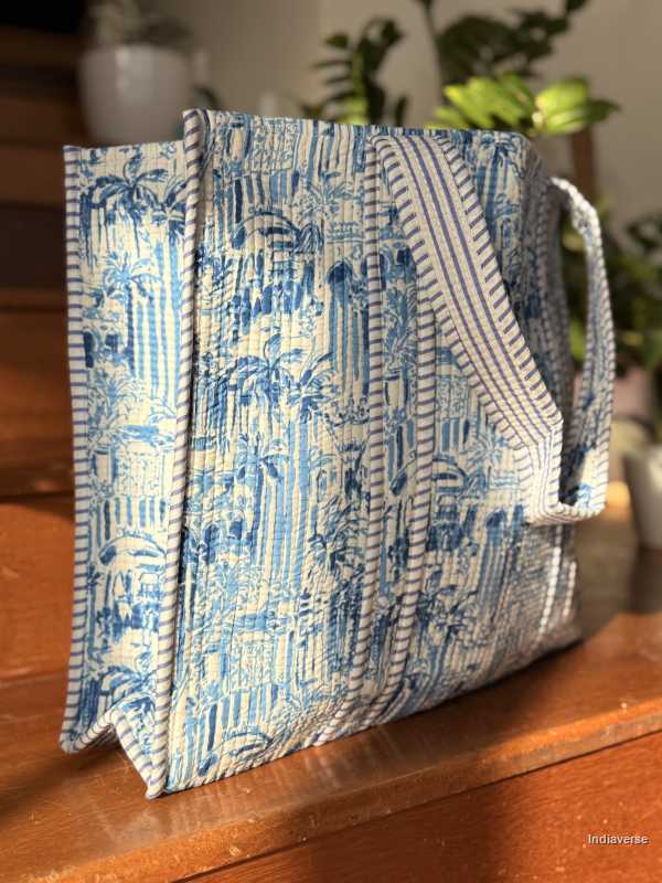 Blue and white patterned fabric bag folded into a box-like shape on a wooden surface.