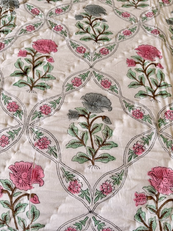 close up of the red and blue flowers printed onto a white cotton quilt