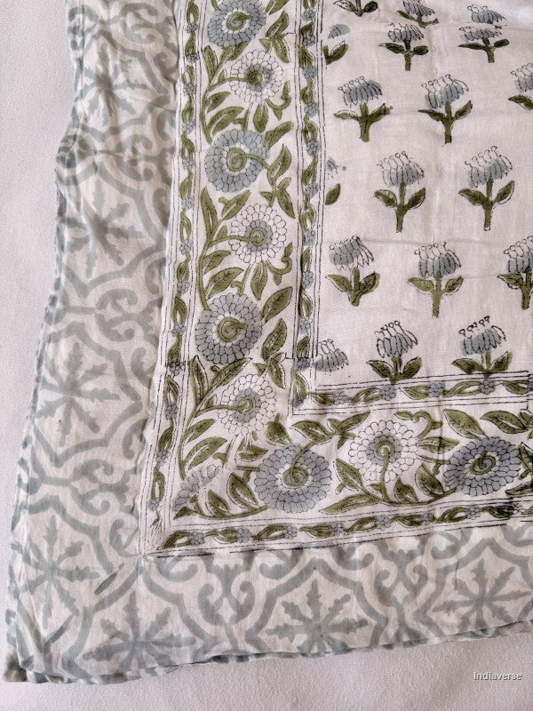 Close up of grey and green floral pattern of the single cotton quilt with geometric border