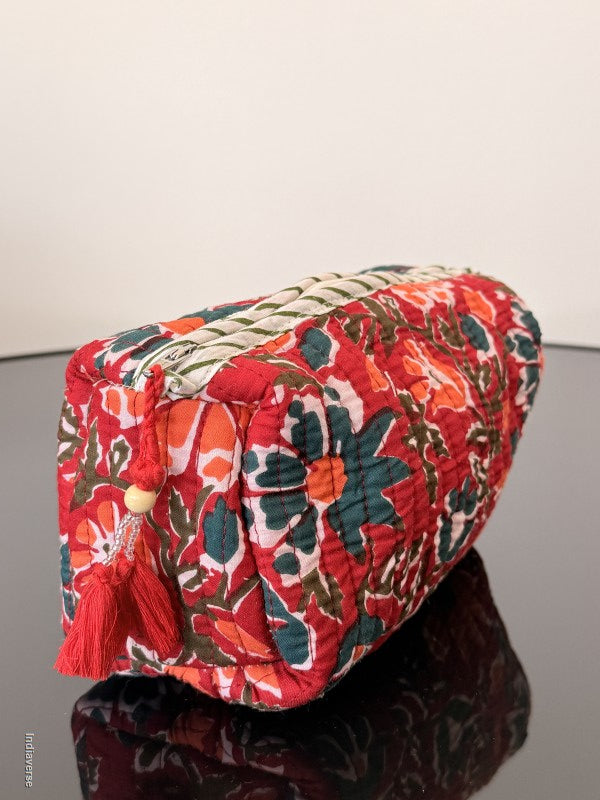 Red floral-patterned bag with tassels on a plain background