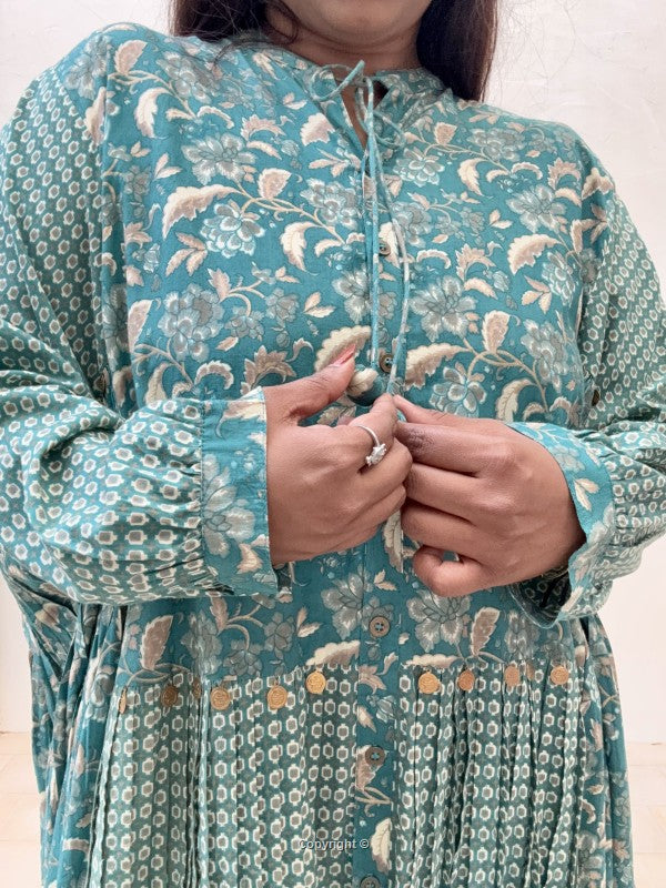 Person wearing a teal floral dress with a white background