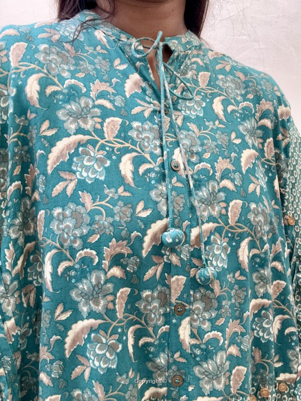 Teal floral patterned shirt with buttons on a plain background