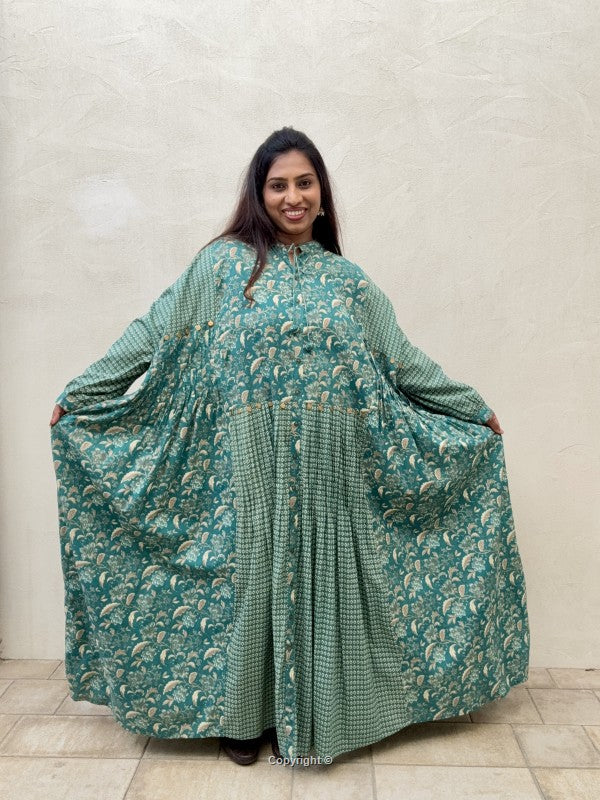 Woman wearing a teal floral dress against a plain background