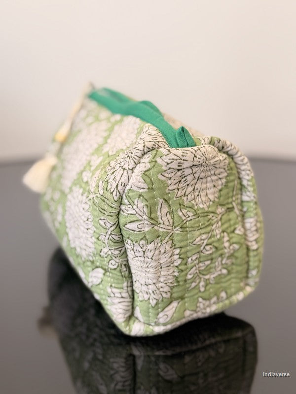 Green and white patterned pouch on a mannequin against a neutral background