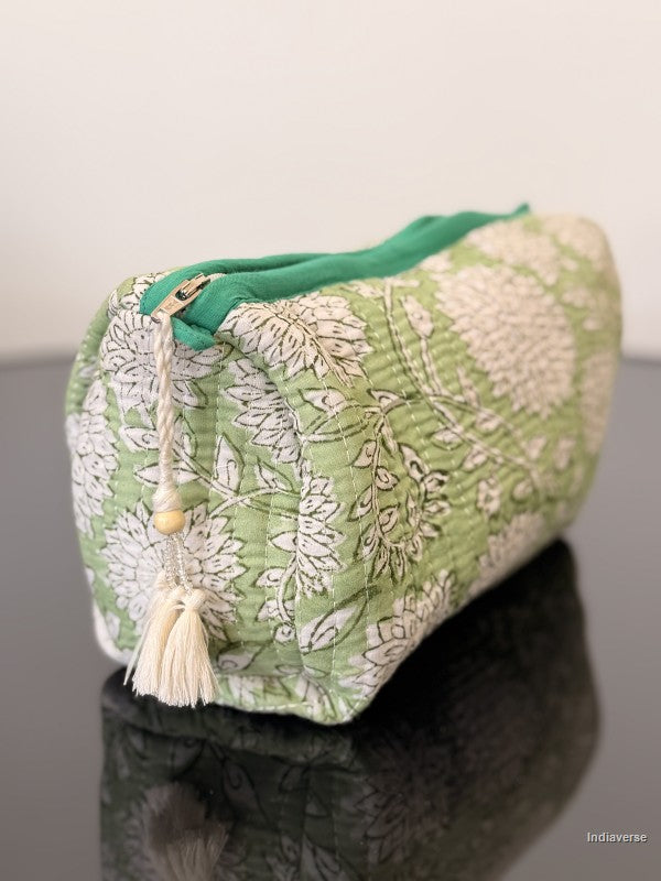 Toiletry pouch with tassel sitting on a glass surface