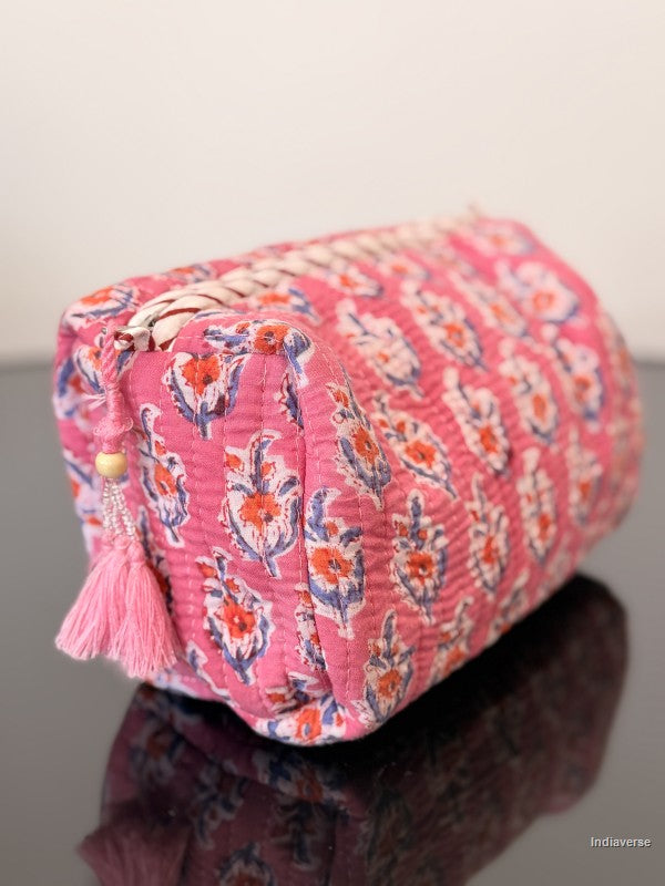 pink fabric pouch with small flowers sitting on a glass surface