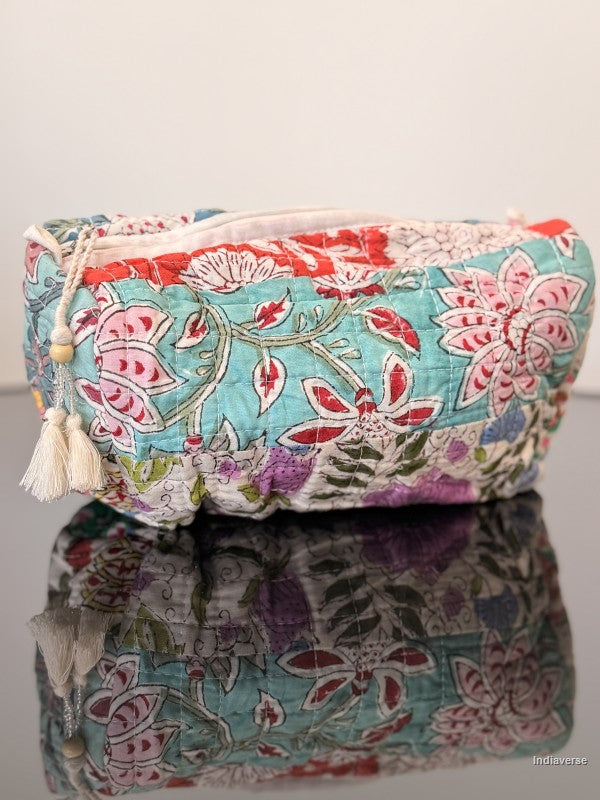 Floral patterned pouch with tassels on a reflective surface