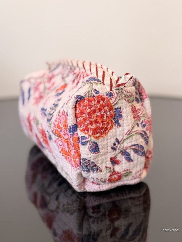 Floral patterned fabric pouch on a reflective surface with a neutral background